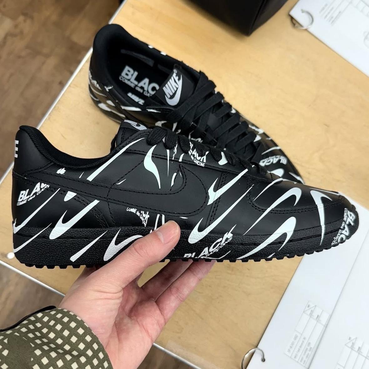 Side profile of the Comme des Garçons BLACK x Nike Field General 82 showcasing the wavy logo design. Side profile of the Comme des Garçons BLACK x Nike Field General 82 showcasing the wavy logo design.