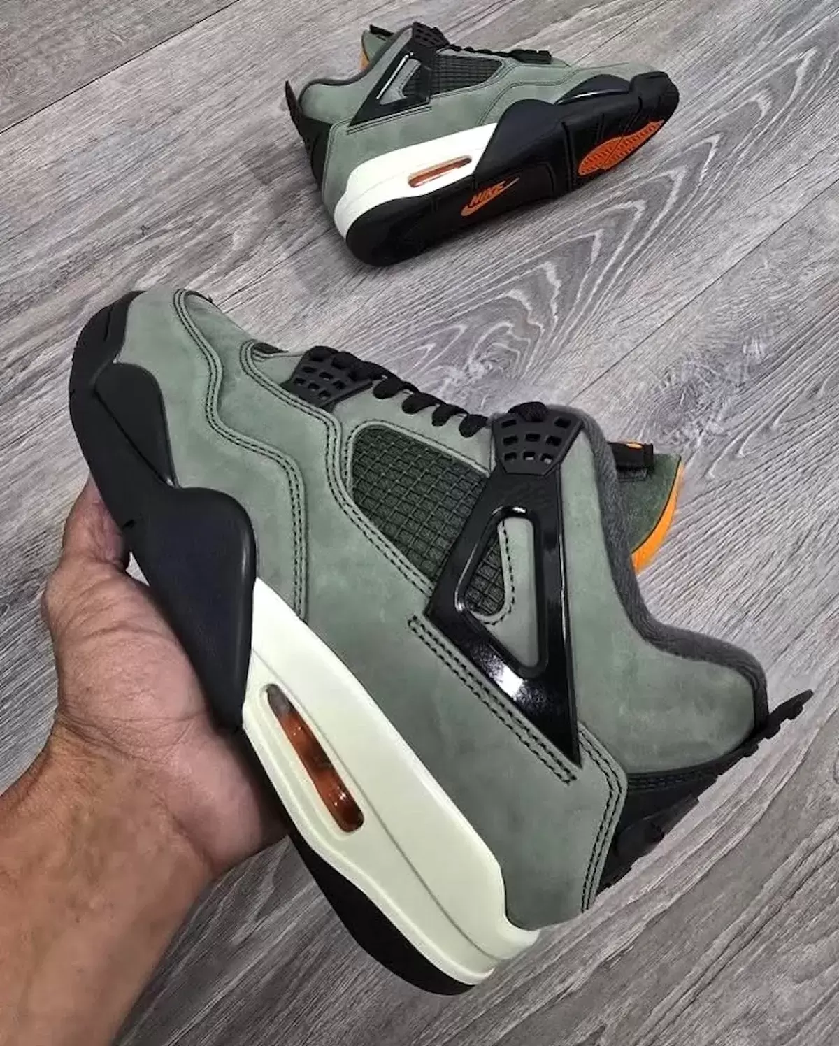 Side view of the Undefeated Air Jordan 4 OG 2025 with Nike Air branding and orange Air unit Side view of the Undefeated Air Jordan 4 OG 2025 with Nike Air branding and orange Air unit