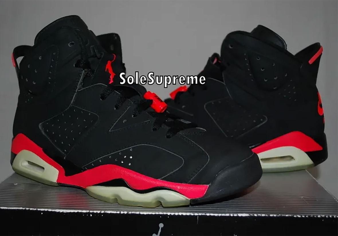 Close-up of the Air Jordan 6 Reverse Infrared original sample showcasing black nubuck uppers, vibrant infrared midsole accents, and icy aged outsoles displayed on top of the retro-style Jordan box. Close-up of the Air Jordan 6 Reverse Infrared original sample showcasing black nubuck uppers, vibrant infrared midsole accents, and icy aged outsoles displayed on top of the retro-style Jordan box.