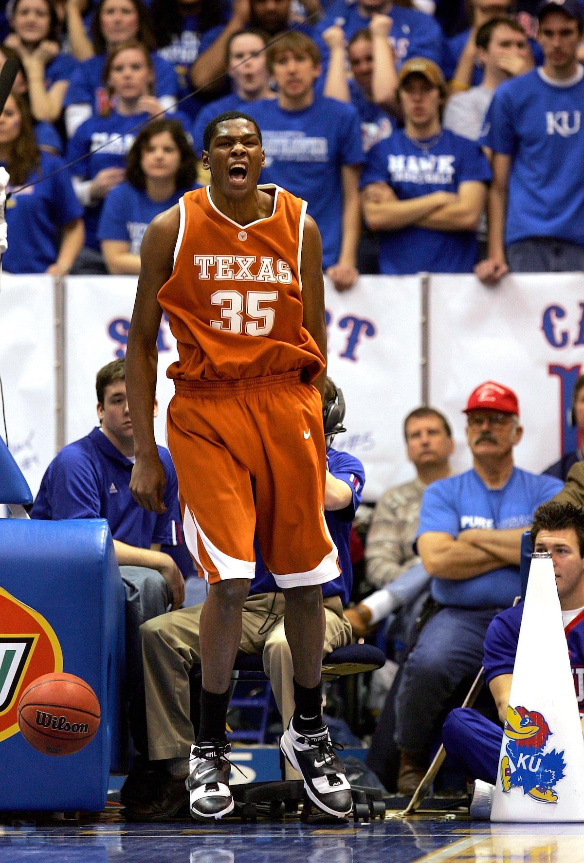 Kevin Durant of the Texas Longhorns passionately celebrates during an NCAA college basketball game against the Kansas Jayhawks. Durant, wearing an orange Texas jersey with number 35, stands near the sideline with fans in the background. Kevin Durant of the Texas Longhorns passionately celebrates during an NCAA college basketball game against the Kansas Jayhawks. Durant, wearing an orange Texas jersey with number 35, stands near the sideline with fans in the background.
