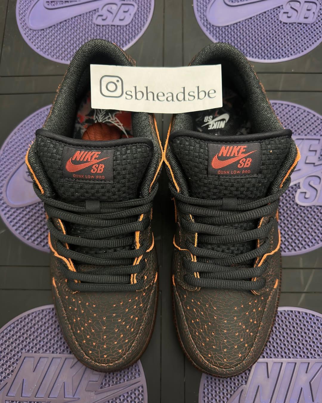 Top-down view of the Nike SB Dunk Low Krampus HV1668-001 sneakers. The black woven tongue features red Nike SB branding, with visible orange stitching and cracked leather detailing on the toe box. Top-down view of the Nike SB Dunk Low Krampus HV1668-001 sneakers. The black woven tongue features red Nike SB branding, with visible orange stitching and cracked leather detailing on the toe box.