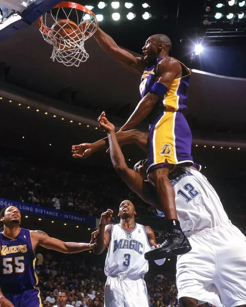 2004 年 11 月 12 日,在湖人隊對陣魔術隊的常規賽中,科比-布萊恩特(Kobe Bryant)在新秀德懷特-霍華德(Dwight Howard)身上完成了一記雷霆萬鈞的扣籃。 Kobe Bryant of the Los Angeles Lakers dunks over Dwight Howard of the Orlando Magic during a 2004 NBA game.