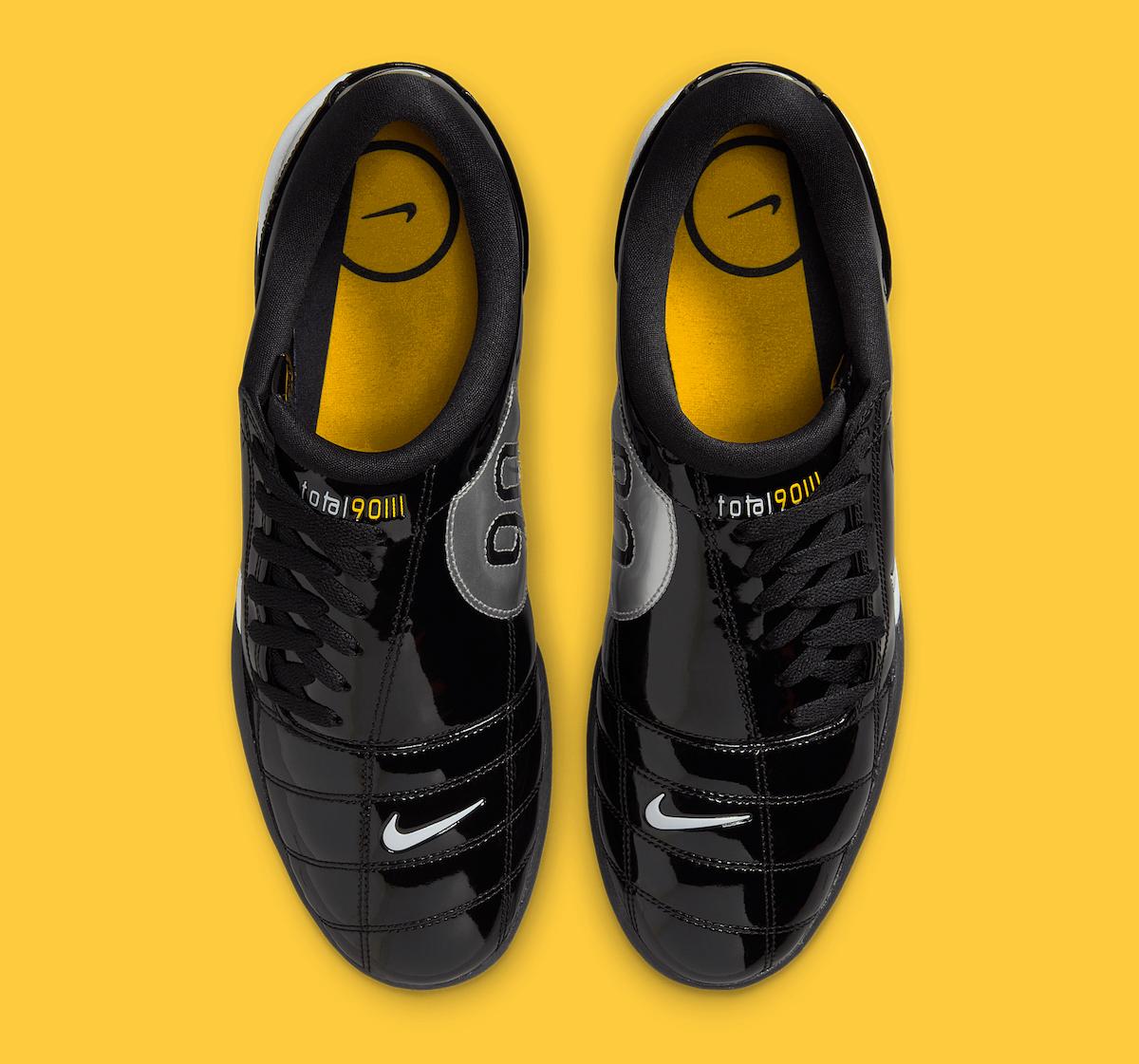 Top-down view of the Nike Total 90 III Black Patent, featuring black laces, yellow insoles with a Nike Swoosh logo, and Total 90 branding on the tongue. Top-down view of the Nike Total 90 III Black Patent, featuring black laces, yellow insoles with a Nike Swoosh logo, and Total 90 branding on the tongue.