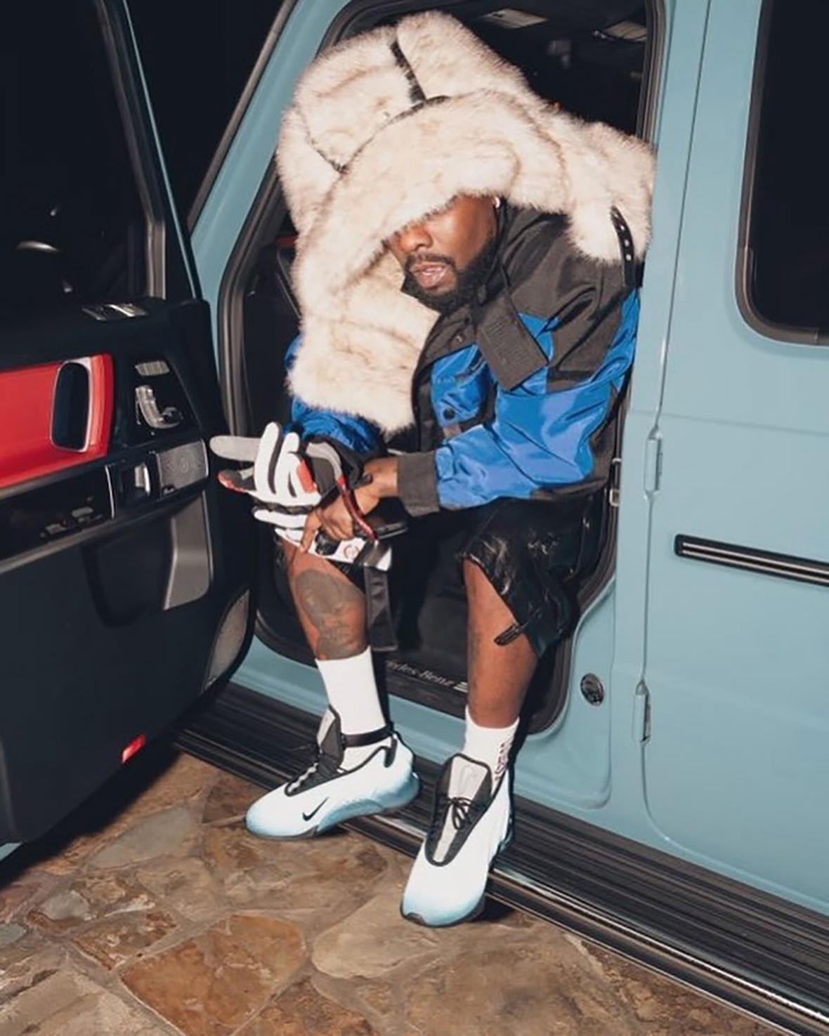 Rapper Wale sitting in a car wearing the Nike GT Future Reflective Blue with a bold outfit.