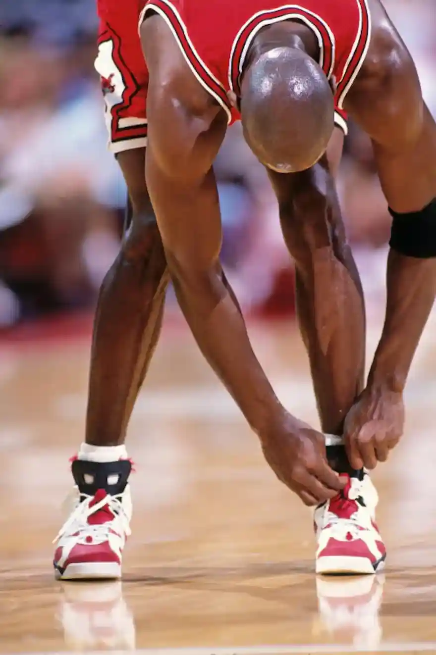Michael Jordan lacing up the Air Jordan 6 Carmine on court